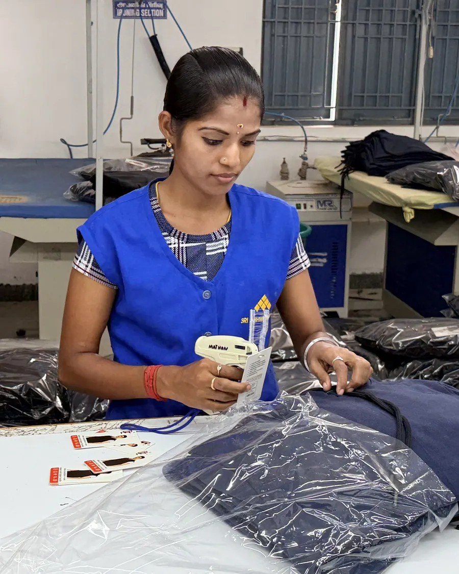 Price tickets being applied to polybagged garments before packing